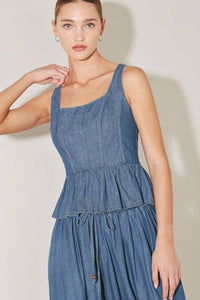 Washed denim peplum top by voglio.us featuring a fitted waist and stylish design, shown on a hanger.