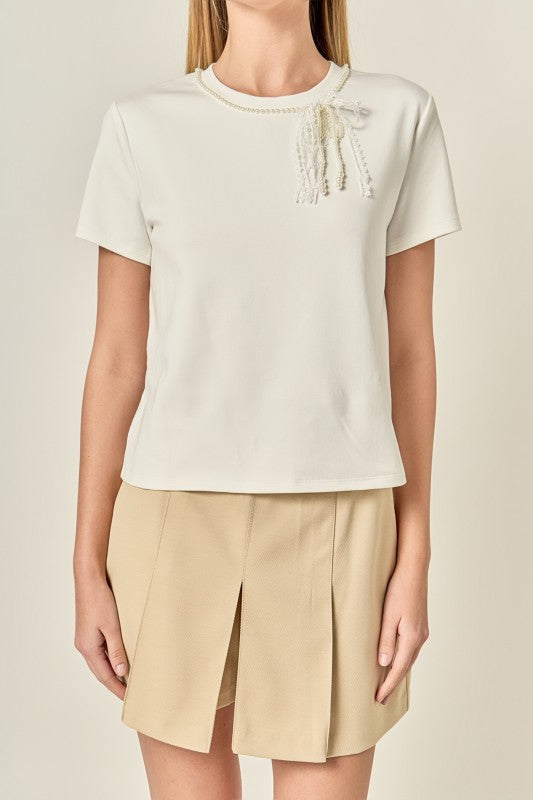 Pearl bow detailed voglio.us top featuring a stylish design with pearl embellishments, perfect for casual or chic outfits.