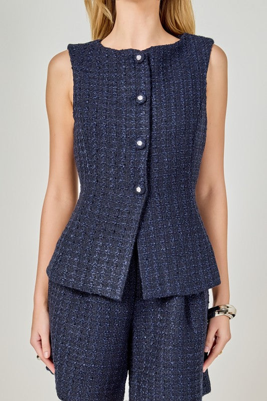 Tweed sleeveless vest with button accents, stylish top from voglio.us, shown in a close-up image.