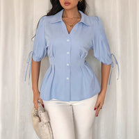 Blue women's office shirt with short sleeves, cuff detail, lace-up design, pleated fit, ideal for spring and summer workwear.