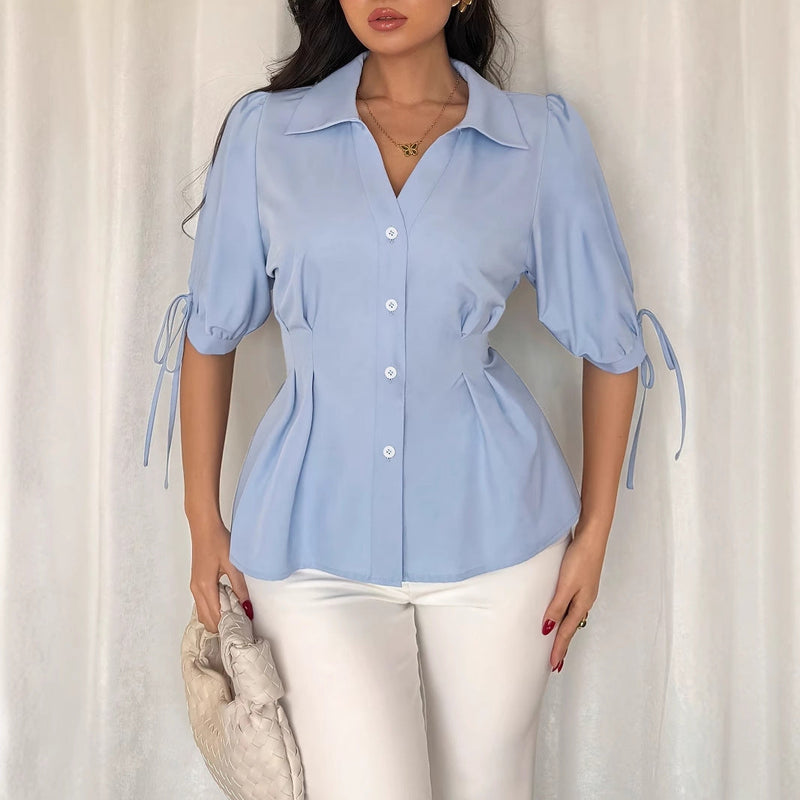 Blue women's office shirt with short sleeves, cuff detail, lace-up design, pleated fit, ideal for spring and summer workwear.