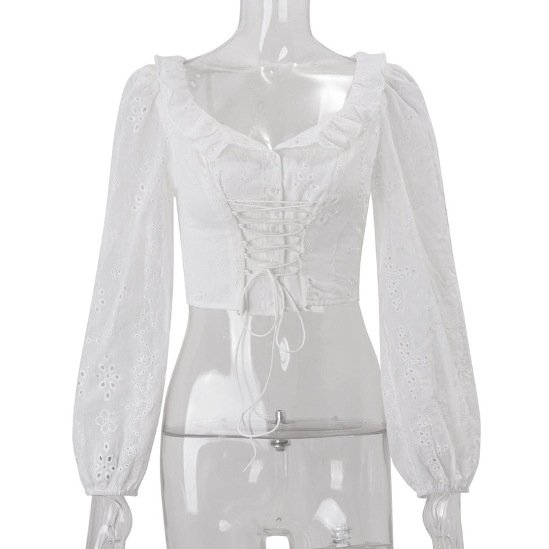 White women's long sleeve crochet crop top with lace-up detail, perfect for autumn fashion, from Wanita Store.