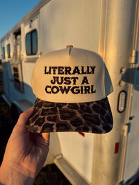 Black "Just a Cowgirl" baseball cap by Western Vogue Boutique, featuring a casual Western-inspired design and adjustable strap.