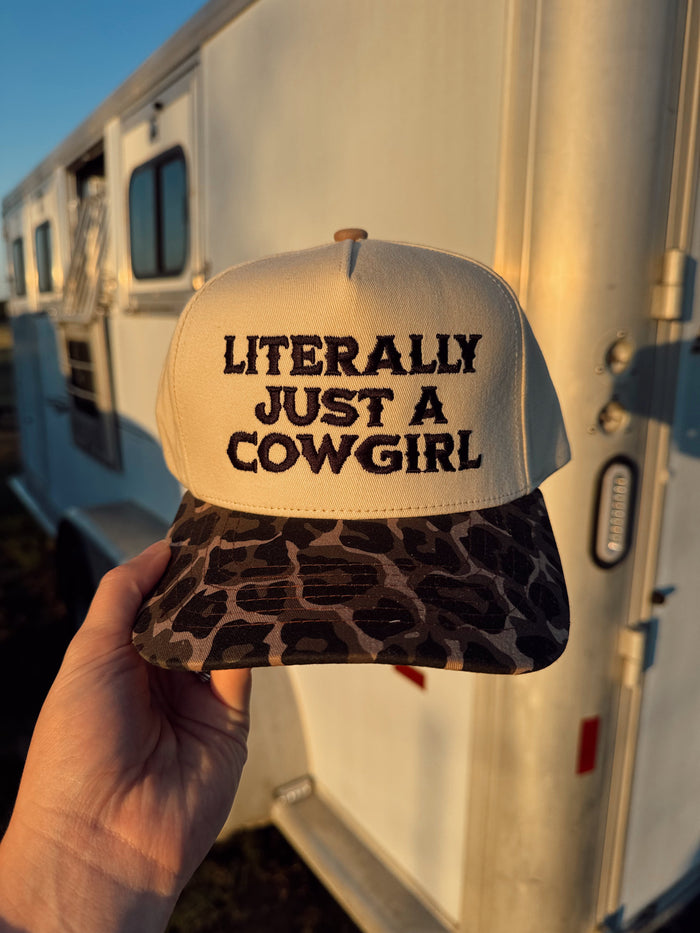Black "Just a Cowgirl" baseball cap by Western Vogue Boutique, featuring a casual Western-inspired design and adjustable strap.