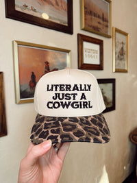 Black "Just a Cowgirl" baseball cap by Western Vogue Boutique, stylish western-inspired adornment with a curved brim and adjustable strap.