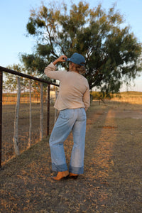 Light wash Cambree jeans by Western Vogue Boutique, showing classic denim bottoms with a relaxed fit and stylish design.