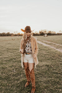 White creamy shorts from Western Vogue Boutique with a relaxed fit, laid out on a flat surface.