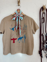 Western Vogue Boutique cowboy-themed T-shirt featuring western-style graphic and casual fit, ideal for western-inspired fashion.