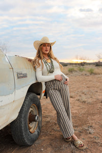 Cream-colored Sloan Top by Western Vogue Boutique, showcasing a stylish, fitted blouse with elegant details on a neutral background.