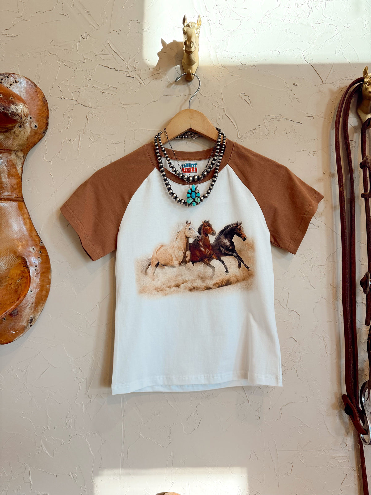 Western Vogue Boutique The Stampede Horses T-Shirt featuring a western horse design on casual top for men or women.