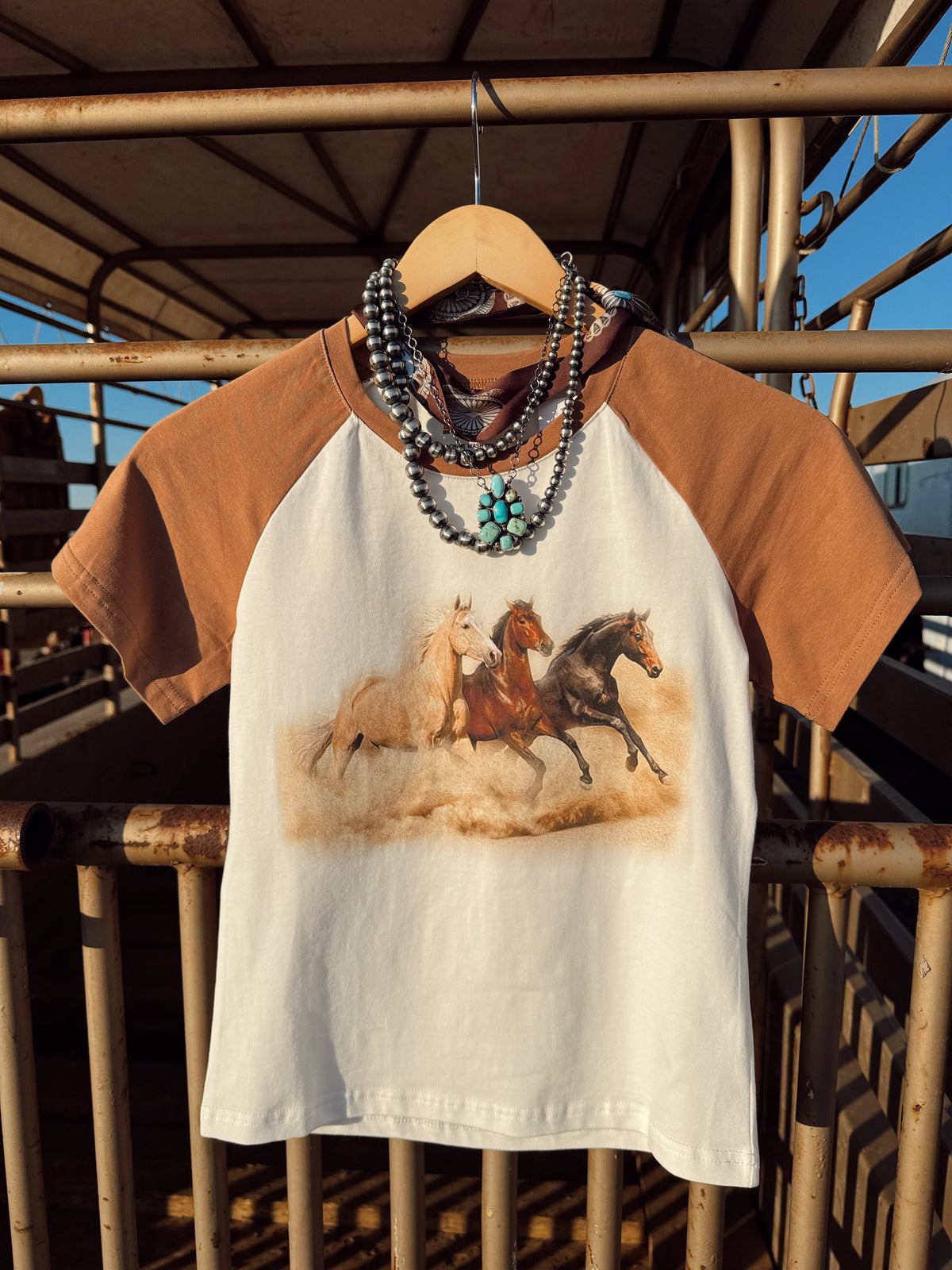 Western Vogue Boutique The Stampede Horses T-Shirt featuring a detailed horse graphic on soft, casual tops.
