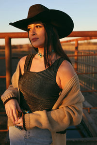 Western Vogue Boutique Opia Top Bodysuit in black, fitted design with long sleeves, displayed on a hanger against a neutral background.