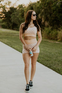 Peach and beige checkered women's gym activewear set by Wild Cactus Boutique, featuring a sports bra and matching leggings.
