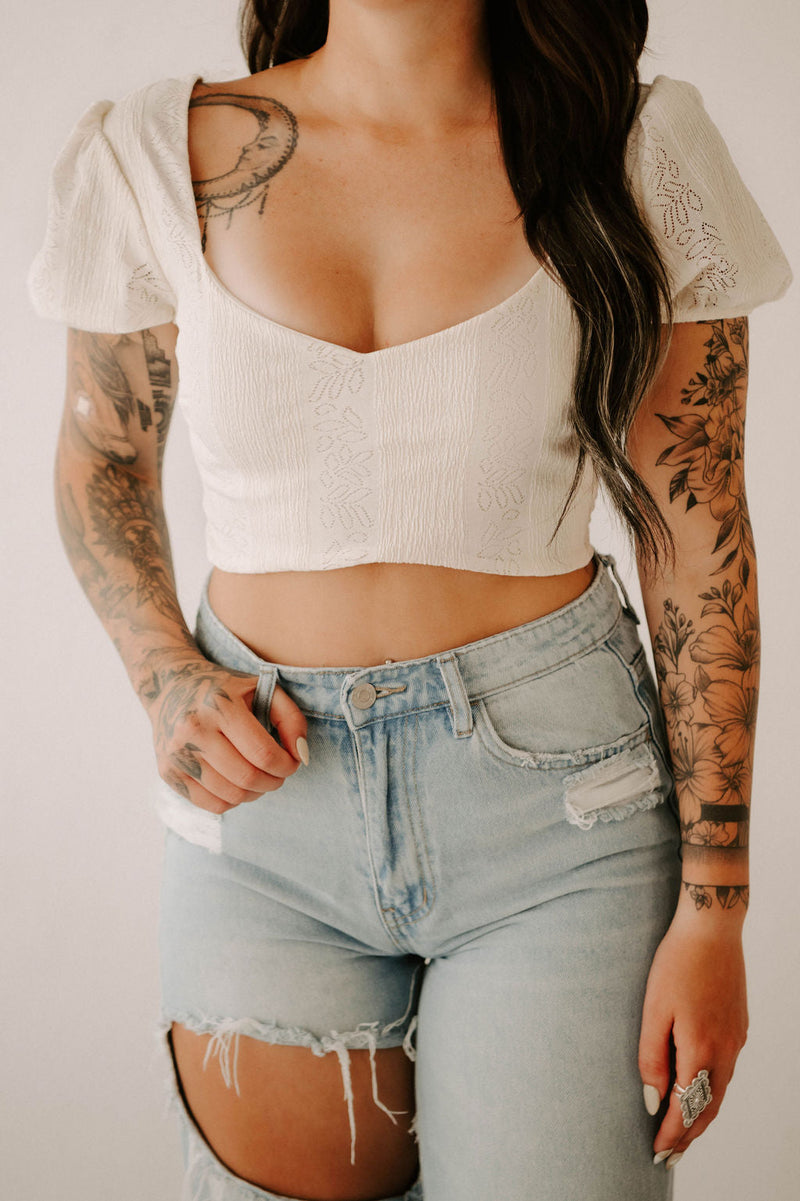 Smocked crop top from Wild Cactus Boutique featuring ruffled neckline and fitted design, perfect for casual summer wear.