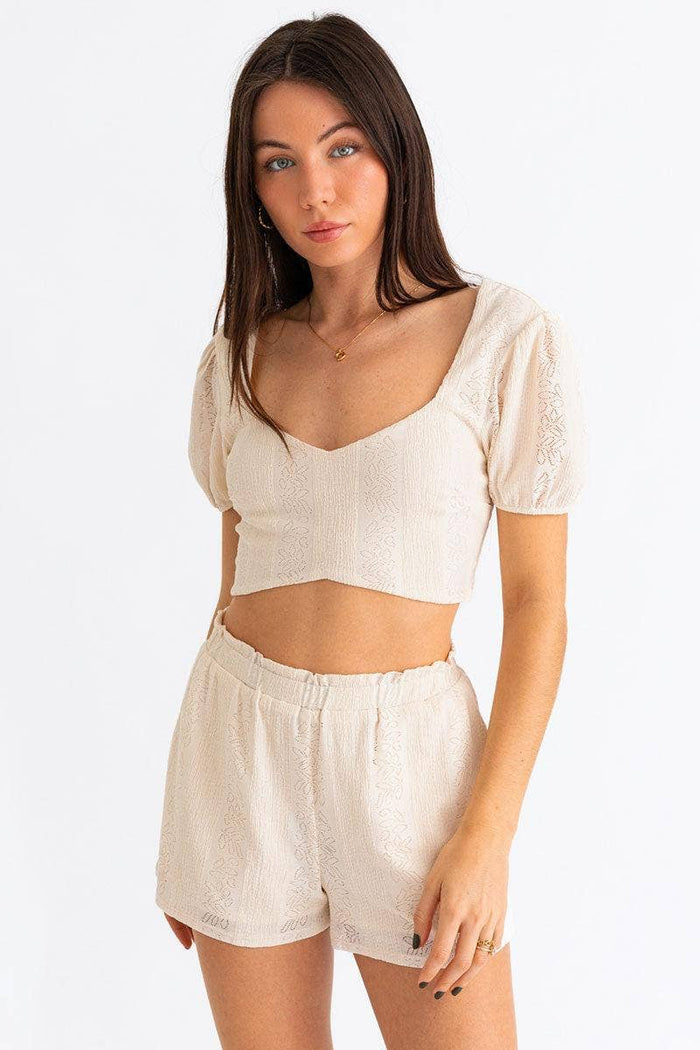 Wild Cactus Boutique smocked crop top featuring a fitted design with stretchy fabric and ruffle details, perfect for casual wear.