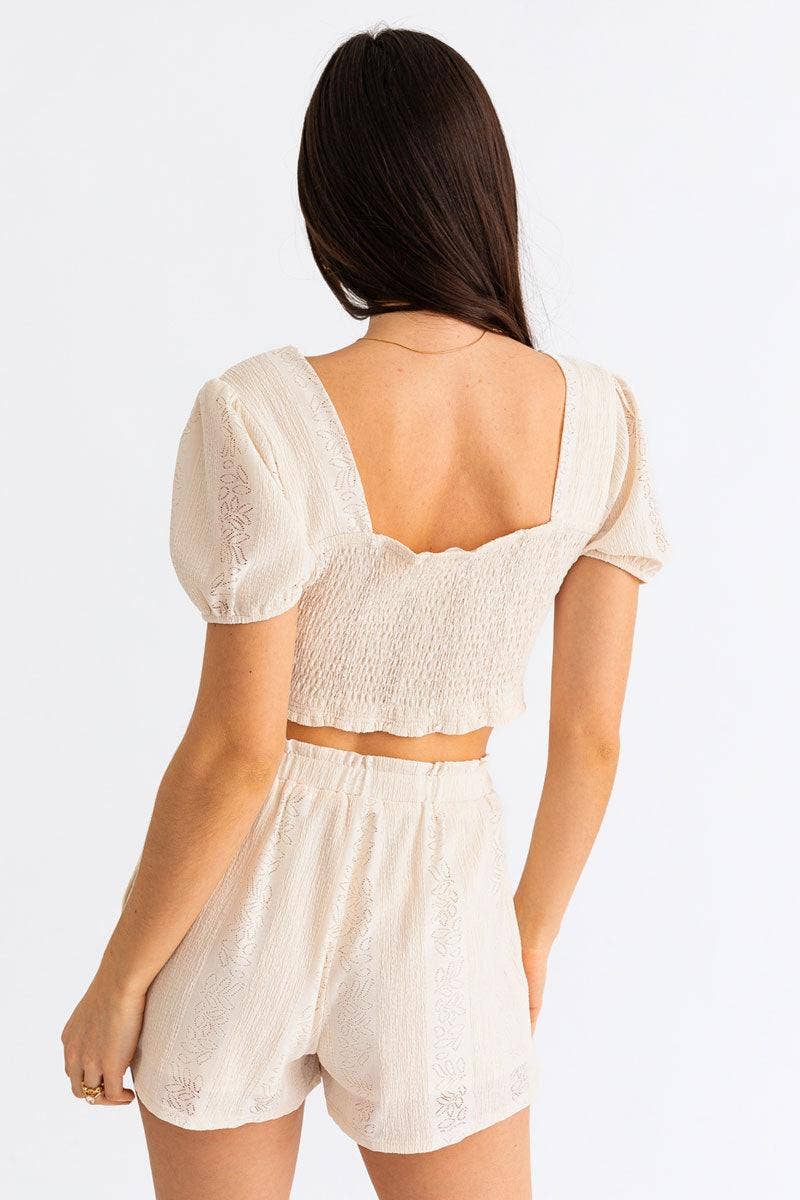 Wild Cactus Boutique smocked crop top featuring ruffled straps and a fitted design, shown on a model against a neutral background.