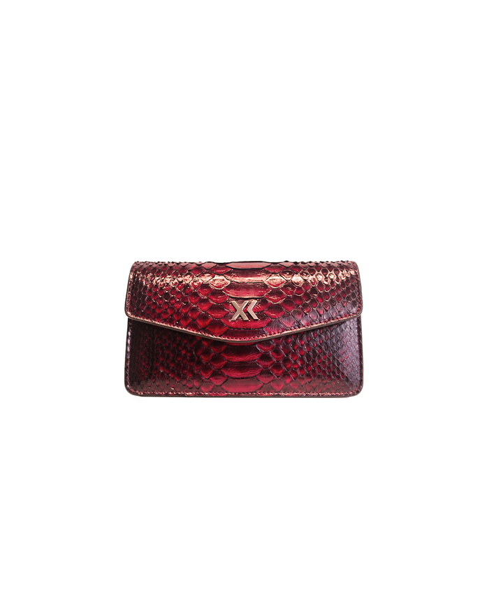 Ximena Kavalekas The Met clutch in midnight red with sleek design and elegant leather finish, shown in a close-up image.