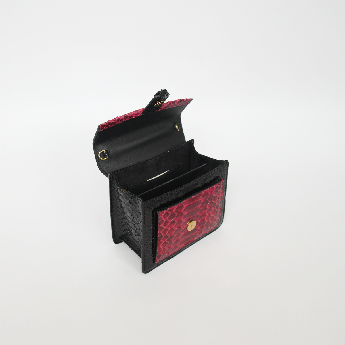 Ximena Kavalekas Emma handbag in wine and black leather with gold-tone hardware and structured design.